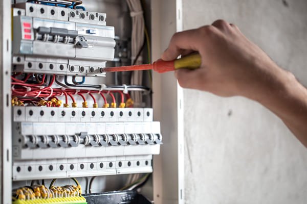 homme-technicien-electricien-travaillant-dans-un-tableau-avec-fusibles-installation-et-connexion-d-equipements-electriques-fermer (1) (1)